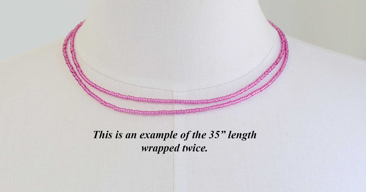 Pink beaded necklace on a mannequin with text indicating length double wrapped 35