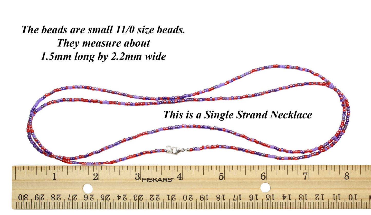 Single strand necklace with beads and a ruler for size reference on a white background