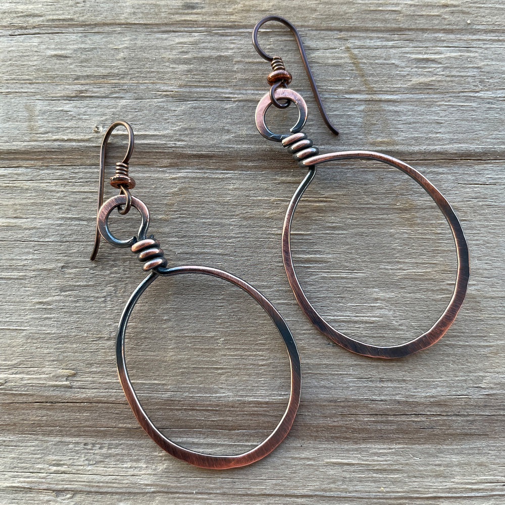 
                      
                        Copper hoop earrings on a wooden surface
                      
                    