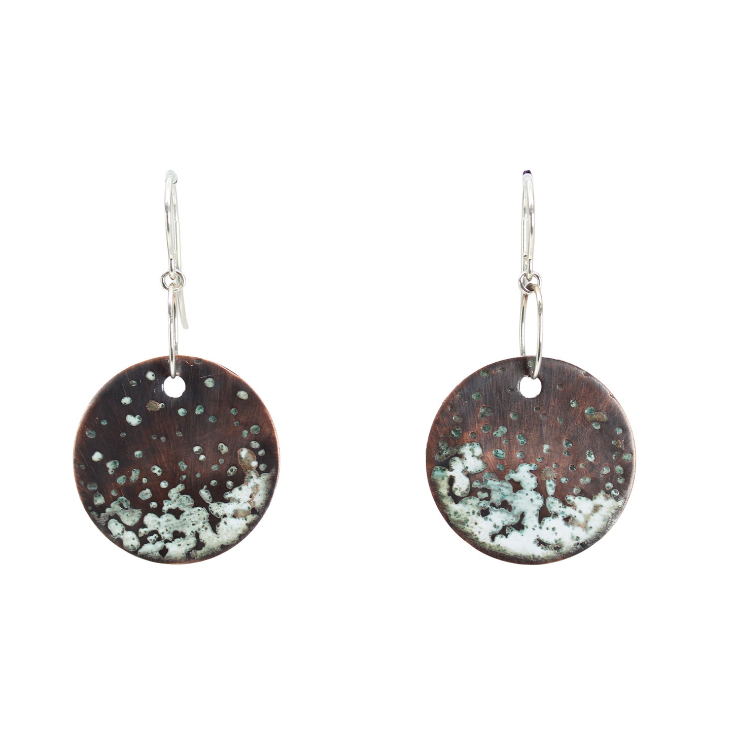 Close-up of textured kiln-fired white enamel on rustic copper disk.