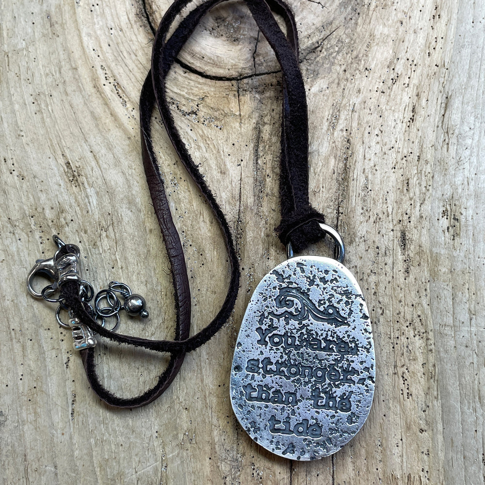 
                      
                        Handcrafted Brown Beach Stone Pendant in Sterling Silver with Deer Skin Lace
                      
                    