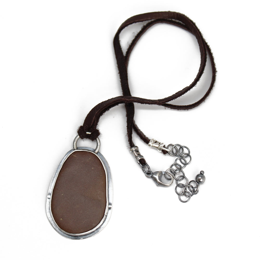 
                      
                        Handcrafted Brown Beach Stone Pendant in Sterling Silver with Deer Skin Lace
                      
                    