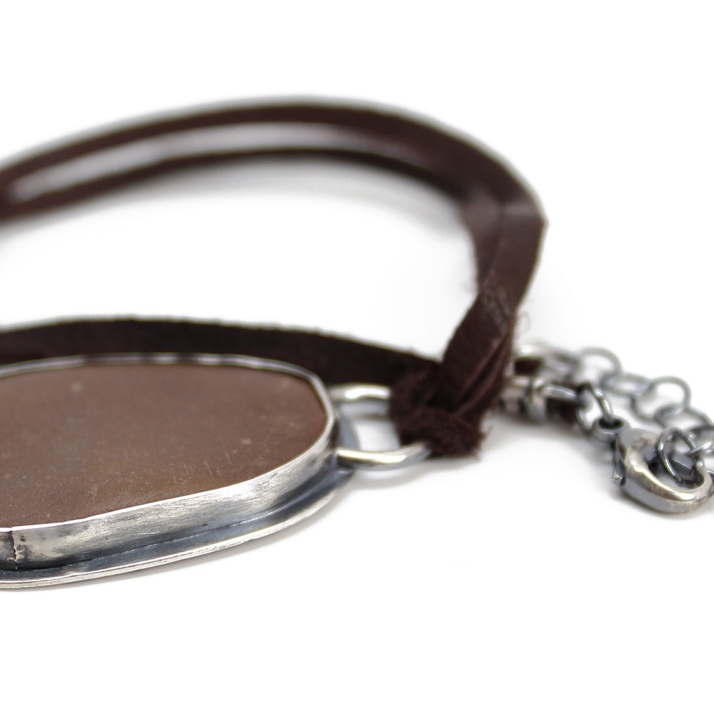 
                      
                        Handcrafted Brown Beach Stone Pendant in Sterling Silver with Deer Skin Lace
                      
                    
