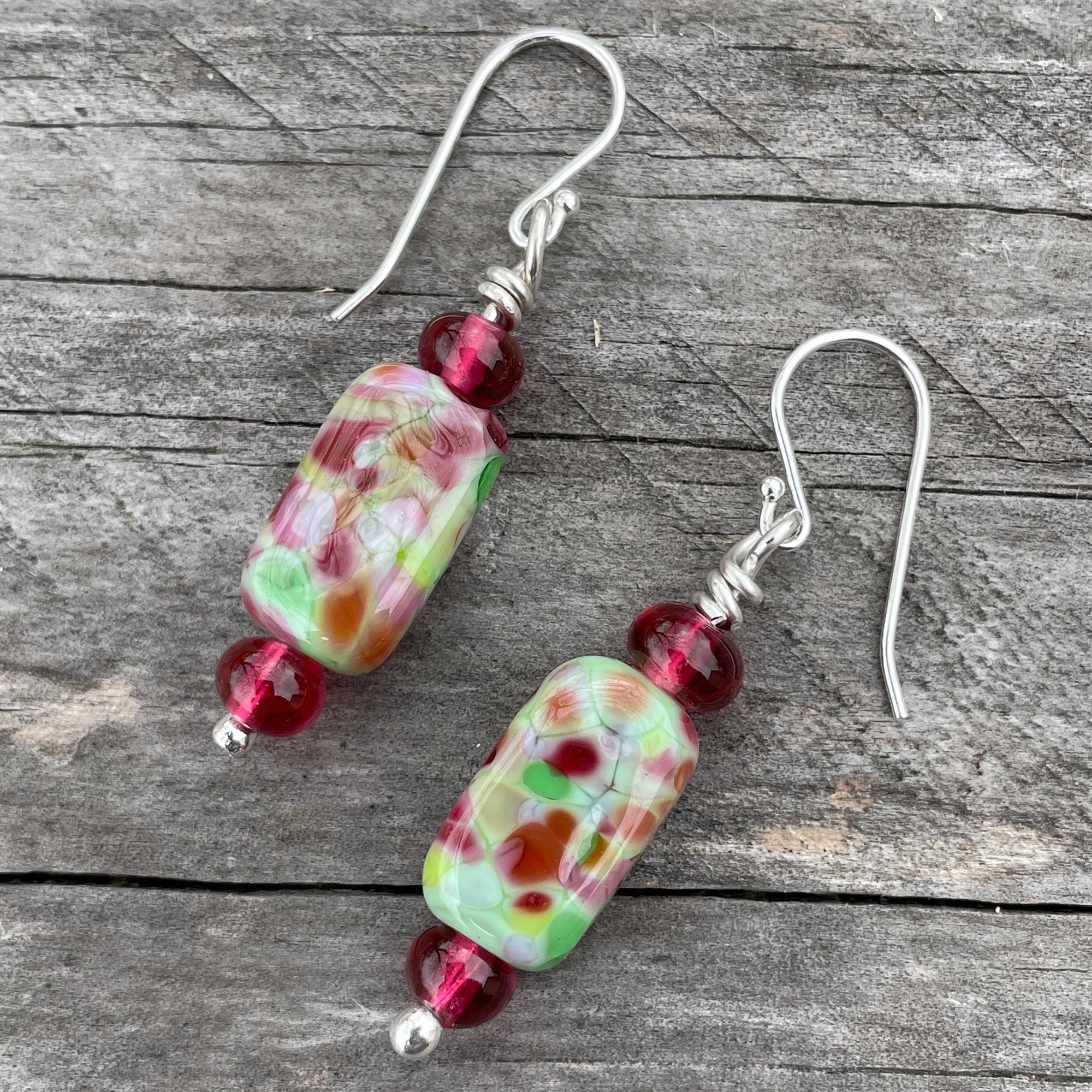 Beautiful lampwork beads in a light cranberry red with silver detail accented with sterling silver bead caps & deals beads. Hangs from sterling.